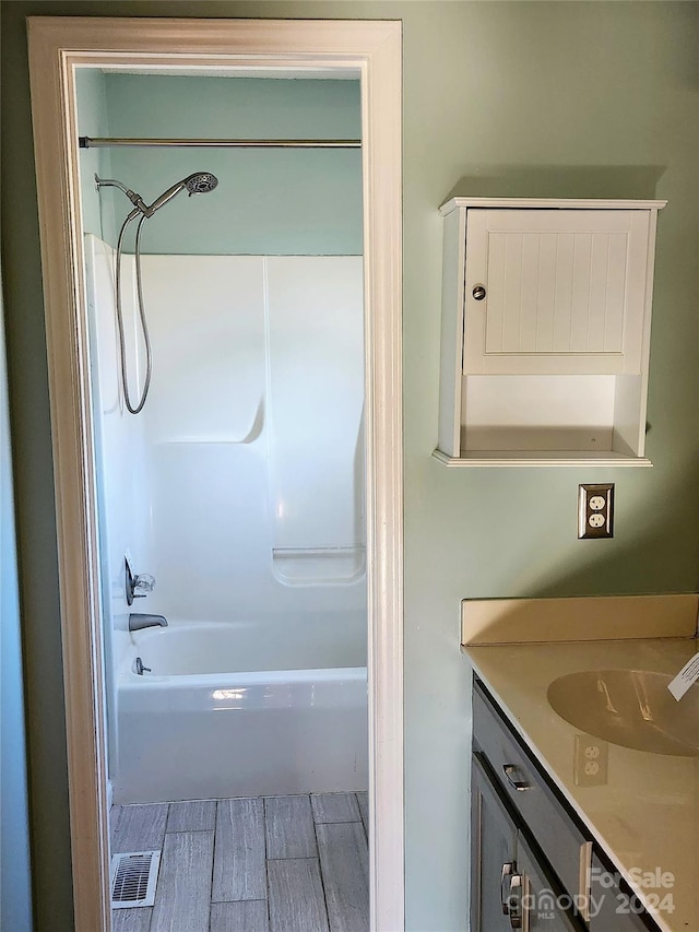 bathroom featuring shower / bathing tub combination, vanity, and hardwood / wood-style flooring