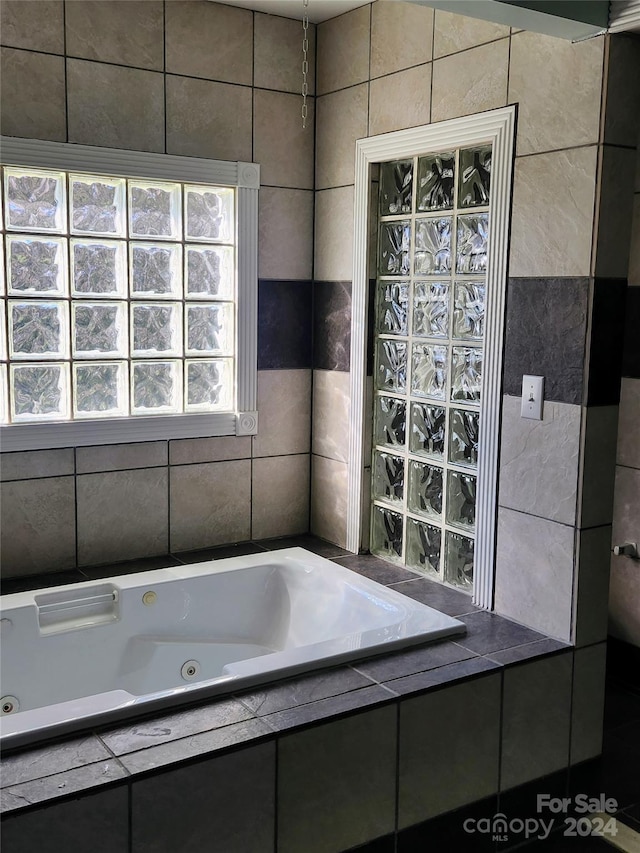 bathroom with tiled tub and tile walls