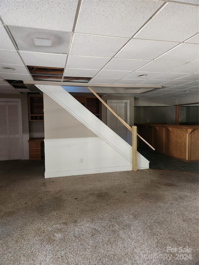 basement with carpet flooring and a paneled ceiling