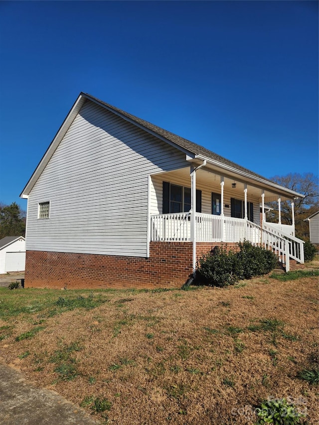 view of home's exterior featuring covered porch and a lawn