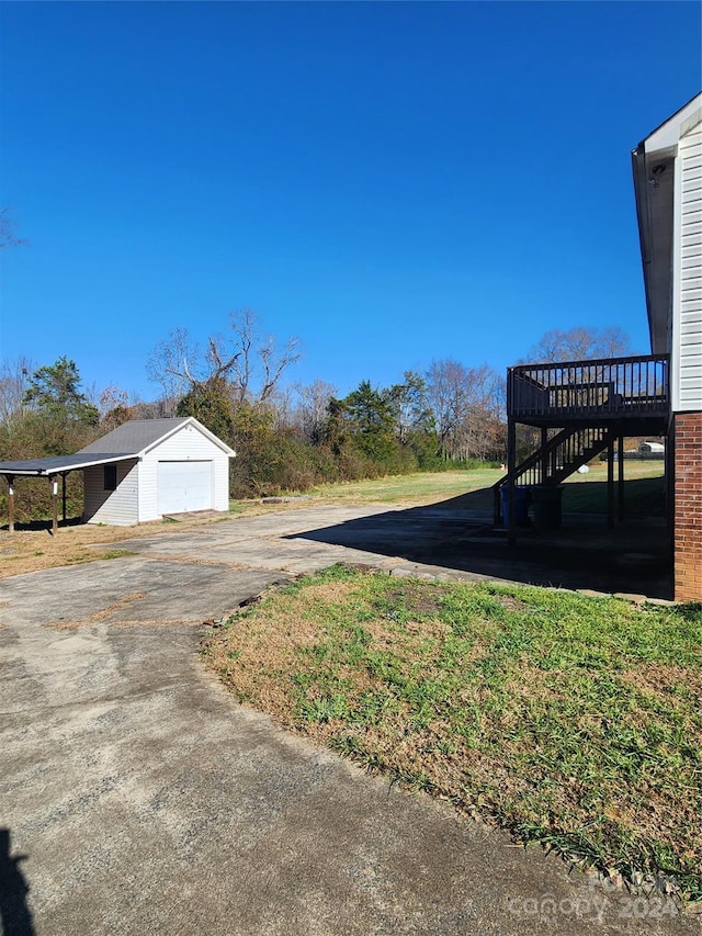 view of yard with a garage, an outdoor structure, and a deck