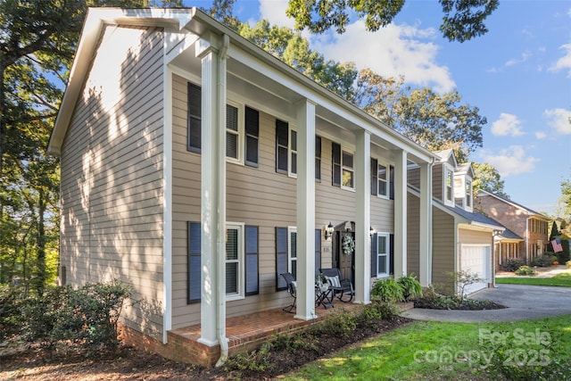 view of side of home featuring a porch and a garage