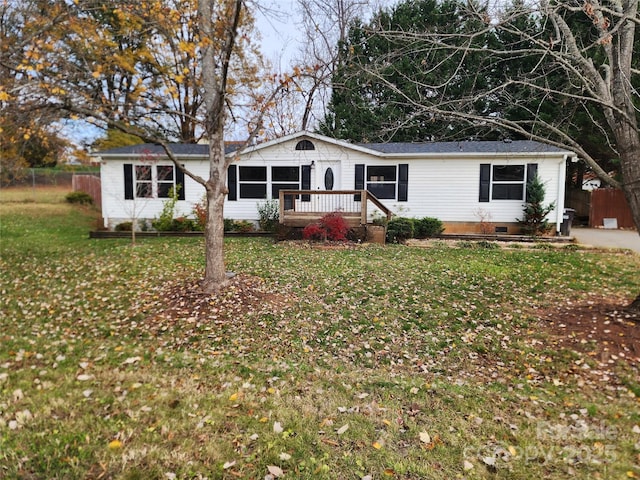 ranch-style house featuring a front yard and a deck