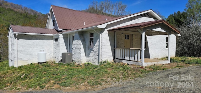 view of front of property with a porch and central AC