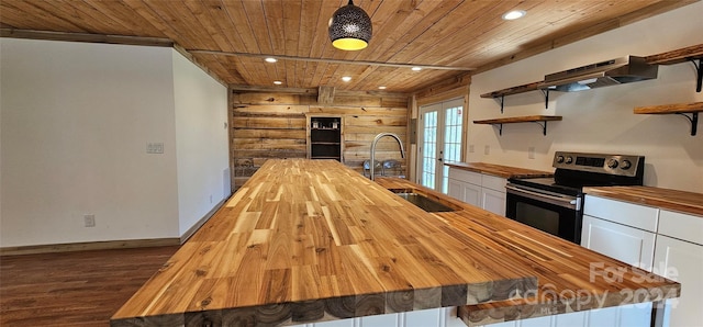 kitchen with white cabinets, wooden counters, stainless steel range with electric cooktop, and wood ceiling