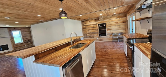 kitchen featuring butcher block counters, wooden ceiling, decorative light fixtures, white cabinetry, and stainless steel appliances