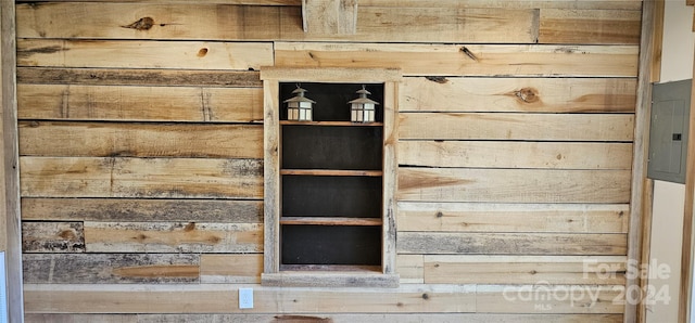 room details featuring wooden walls and electric panel