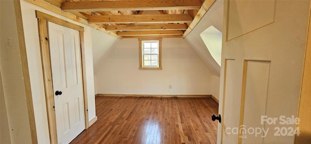 bonus room with hardwood / wood-style flooring and vaulted ceiling with beams