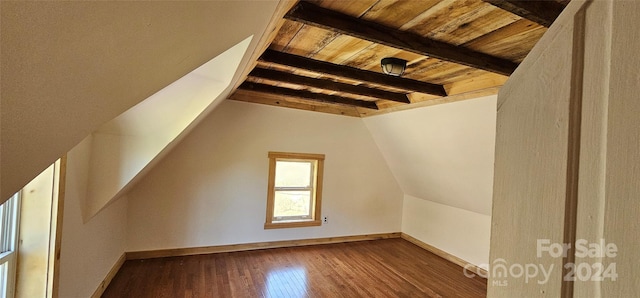 additional living space with vaulted ceiling with beams, wood ceiling, and dark wood-type flooring