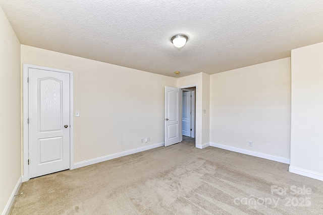 carpeted empty room featuring a textured ceiling