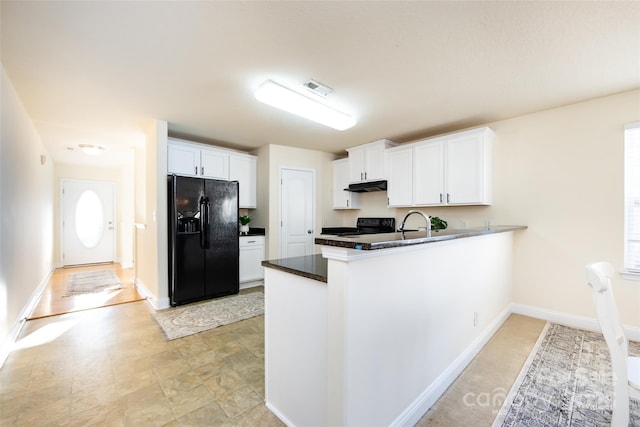 kitchen featuring electric range oven, sink, white cabinets, kitchen peninsula, and black fridge