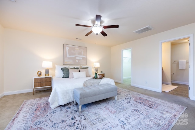 carpeted bedroom with ensuite bath and ceiling fan