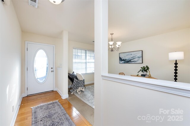 entrance foyer featuring light hardwood / wood-style flooring and a chandelier