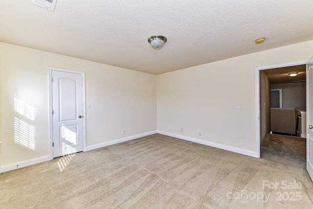 carpeted empty room with a textured ceiling