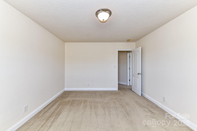 unfurnished room featuring light carpet and a textured ceiling