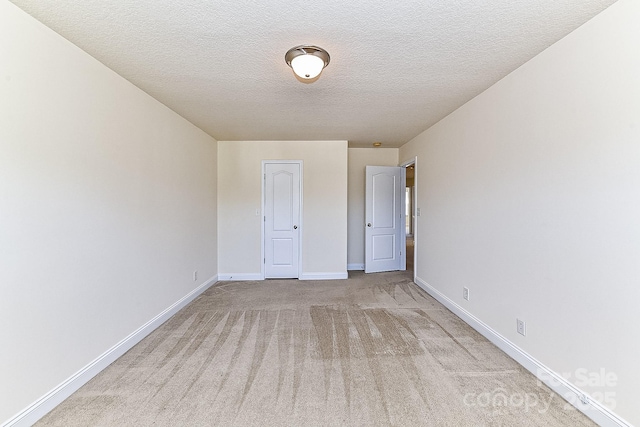 unfurnished bedroom with light colored carpet and a textured ceiling