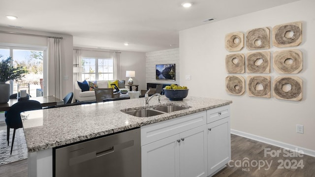 kitchen with dark wood-type flooring, sink, stainless steel dishwasher, light stone countertops, and white cabinetry