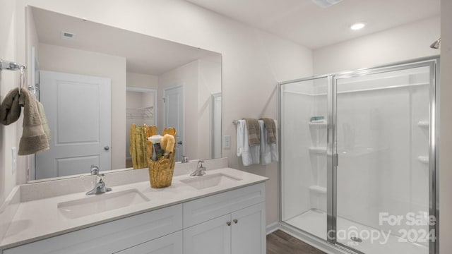 bathroom featuring wood-type flooring, vanity, and walk in shower