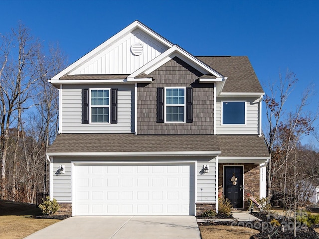 15533 Capps Rd, Charlotte, NC 28278 - view of front facade featuring concrete driveway, an attached garage, board and batten siding, a shingled roof, and stone siding