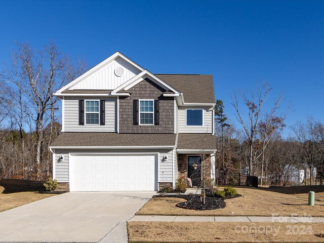 15533 Capps Rd, Charlotte, NC 28278 - view of front facade featuring an attached garage, driveway, a shingled roof, stone siding, and board and batten siding