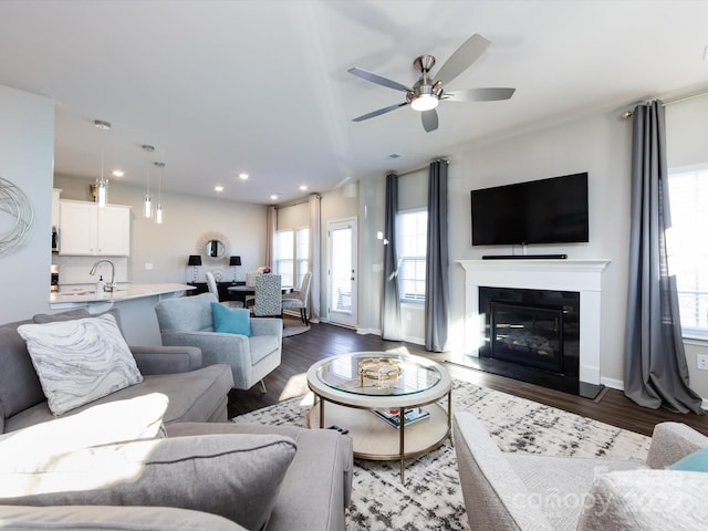 15533 Capps Rd, Charlotte, NC 28278 - living room featuring healthy amount of natural light, a ceiling fan, wood finished floors, recessed lighting, and a glass covered fireplace