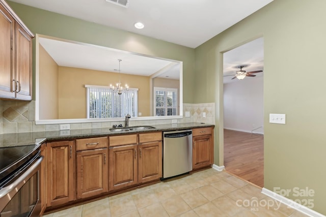 kitchen with sink, stainless steel appliances, dark stone countertops, and tasteful backsplash