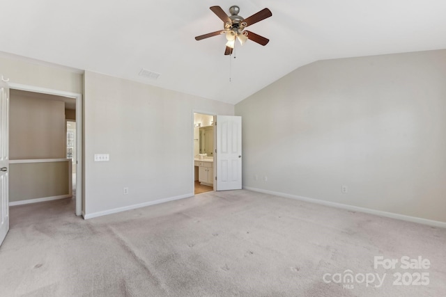 unfurnished bedroom with lofted ceiling, light colored carpet, ensuite bath, and ceiling fan