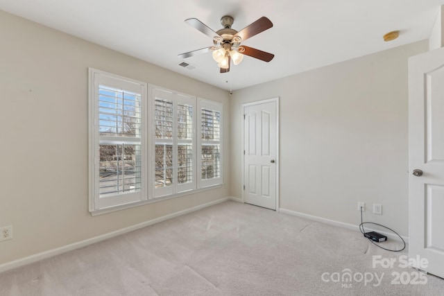 empty room featuring ceiling fan and light colored carpet