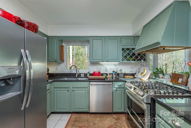 kitchen featuring stainless steel appliances, green cabinetry, sink, and island exhaust hood