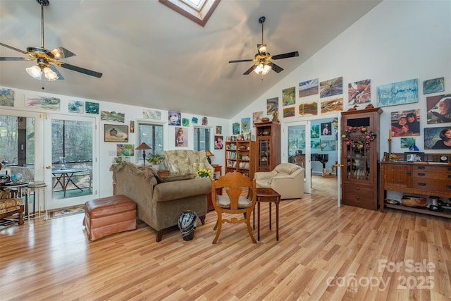 living room with light hardwood / wood-style floors, a skylight, french doors, and ceiling fan