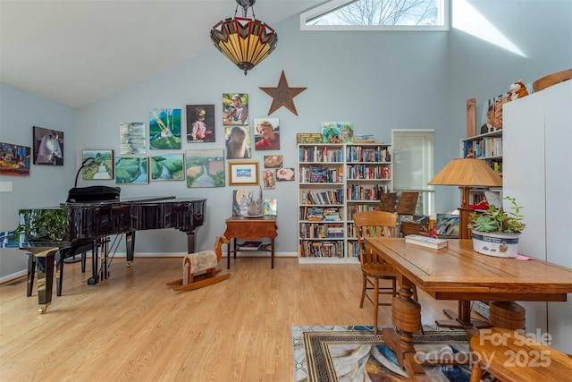 office with light hardwood / wood-style floors and high vaulted ceiling