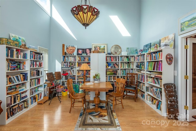 sitting room featuring a high ceiling and light wood-type flooring