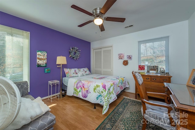 bedroom with ceiling fan, a closet, and wood-type flooring