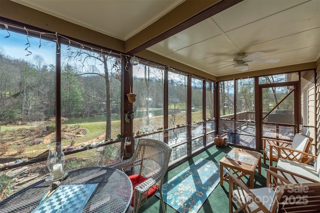 unfurnished sunroom featuring ceiling fan