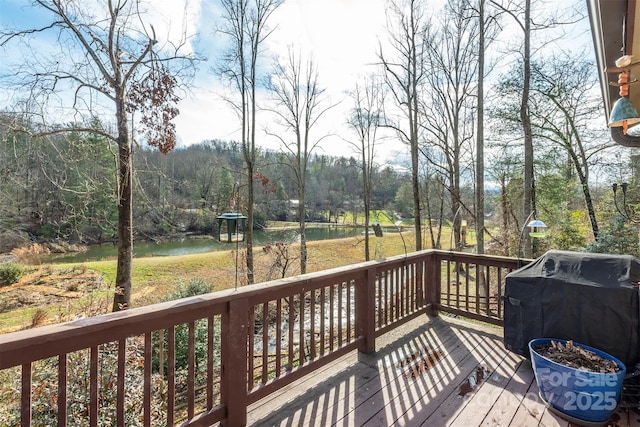 wooden deck featuring a water view and grilling area