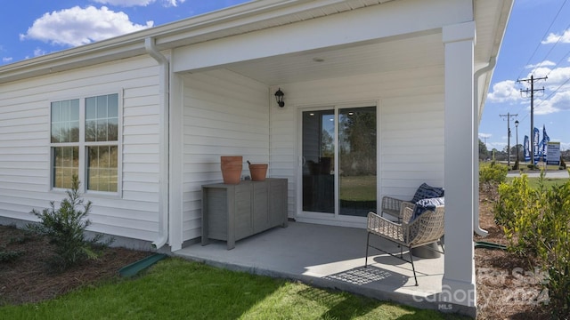 view of exterior entry with a patio area