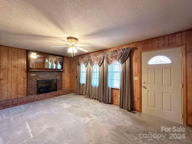 unfurnished living room with plenty of natural light, a fireplace, and light carpet