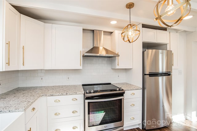 kitchen featuring wall chimney exhaust hood, decorative backsplash, decorative light fixtures, white cabinetry, and stainless steel appliances