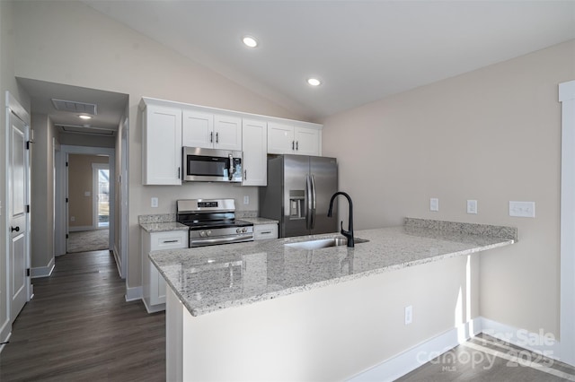 kitchen with white cabinetry, kitchen peninsula, appliances with stainless steel finishes, light stone countertops, and sink