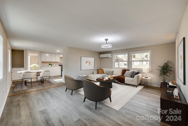 living room featuring light hardwood / wood-style flooring and a wall unit AC