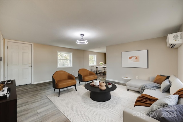 living room with hardwood / wood-style floors and an AC wall unit