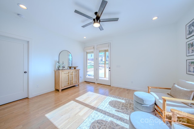 living area with light hardwood / wood-style flooring and ceiling fan