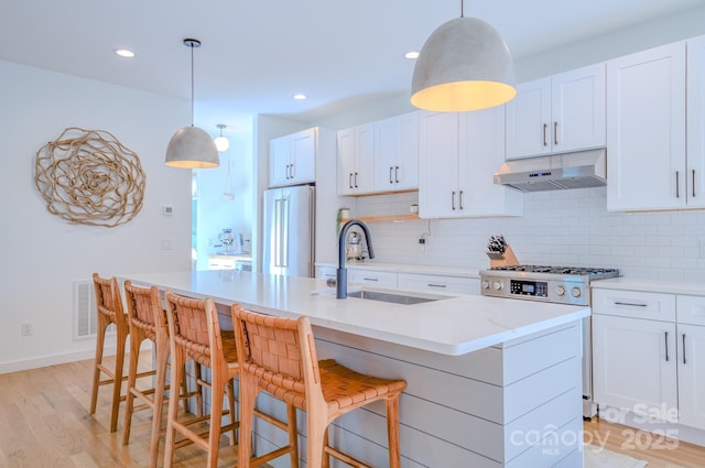 kitchen featuring white cabinets, premium appliances, and sink