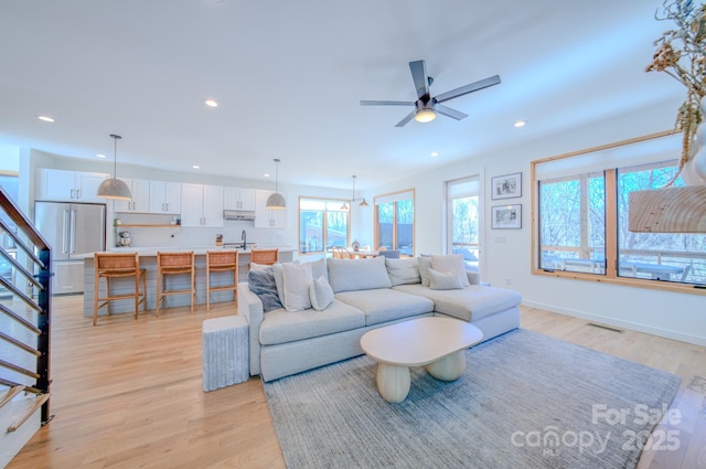 living room with light hardwood / wood-style flooring and ceiling fan