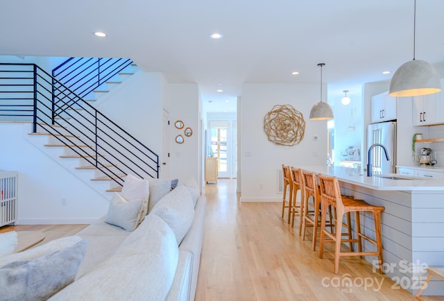 living room featuring sink and light hardwood / wood-style flooring