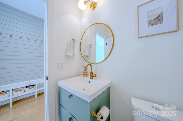 bathroom featuring wood-type flooring, vanity, and toilet