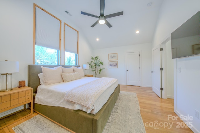 bedroom with ceiling fan, vaulted ceiling, and light hardwood / wood-style flooring