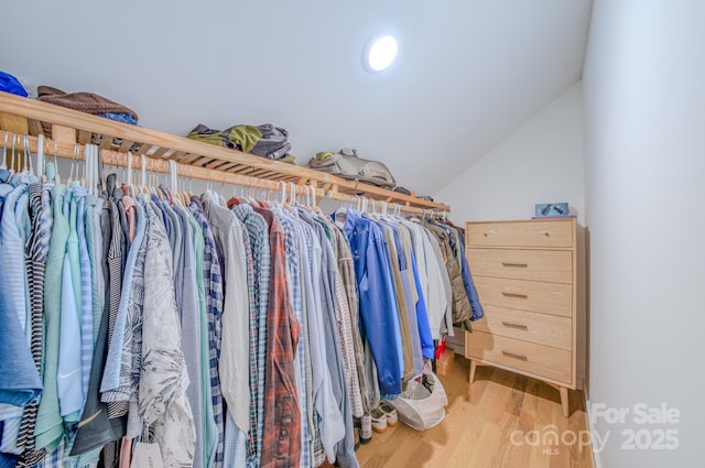 spacious closet featuring hardwood / wood-style flooring and vaulted ceiling