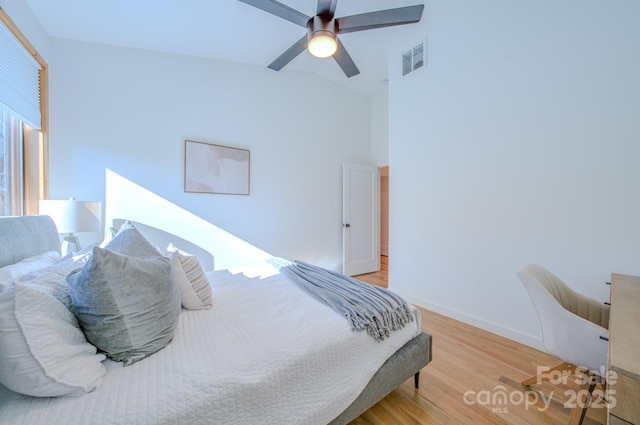 bedroom featuring light hardwood / wood-style floors, vaulted ceiling, and ceiling fan