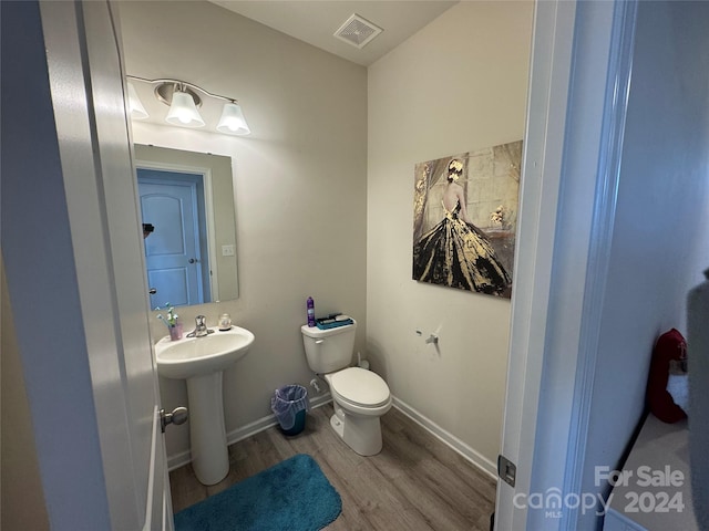 bathroom featuring hardwood / wood-style flooring, toilet, and sink